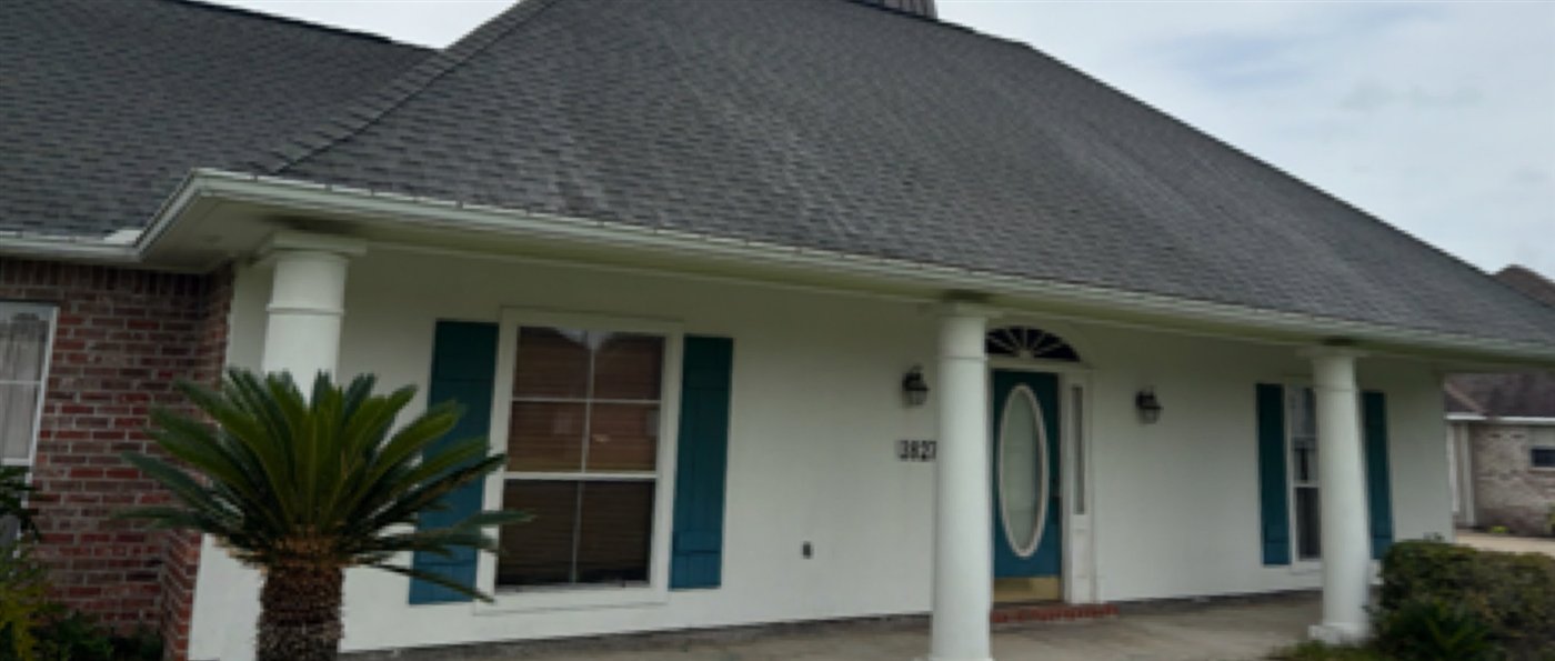 Home with a dark, dirty roof before cleaning